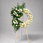Floral wreath with white flowers and greenery on a gray background